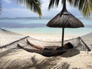 Frau liegt in Hängematte am Strand zur Erholung