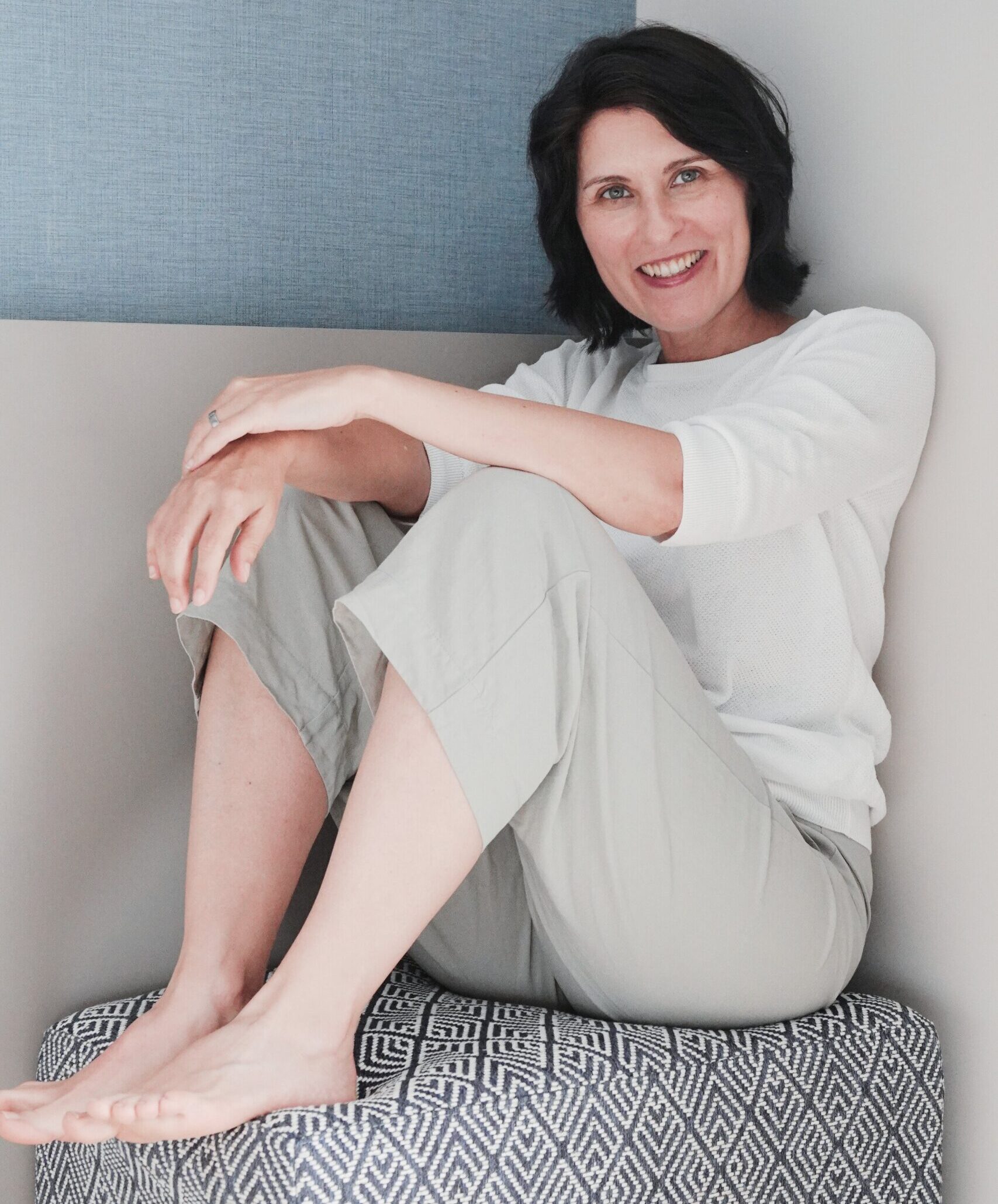 Iris sitzt auf Hocker und lacht