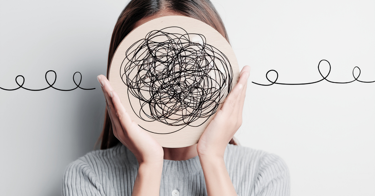 Frau mit runden Karton vor dem Kopf, der anzeigen soll, dass sie mental überlastet ist