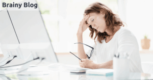 Gestresste, erschöpfte Frau in der Arbeit vor Computerbildschirm mit überreiztem Nervensystem